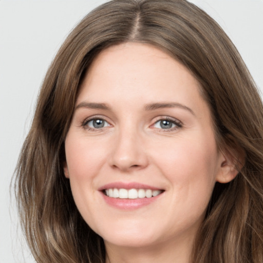 Joyful white young-adult female with long  brown hair and grey eyes