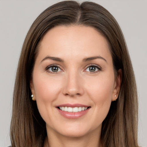 Joyful white young-adult female with long  brown hair and grey eyes