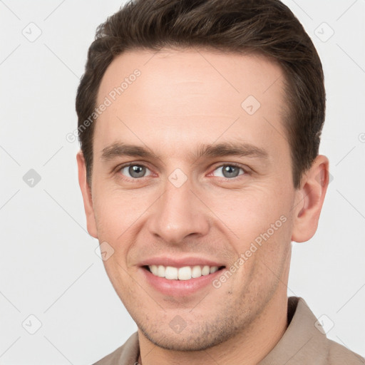 Joyful white young-adult male with short  brown hair and grey eyes