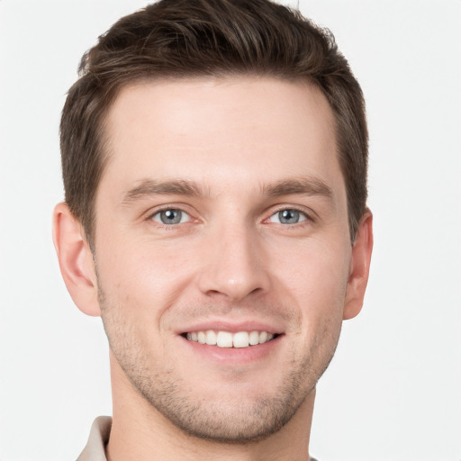 Joyful white young-adult male with short  brown hair and grey eyes