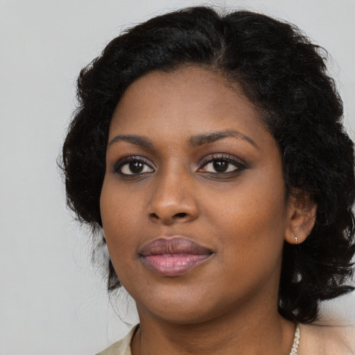 Joyful black young-adult female with long  black hair and brown eyes