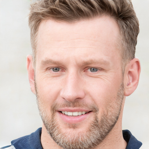 Joyful white adult male with short  brown hair and blue eyes