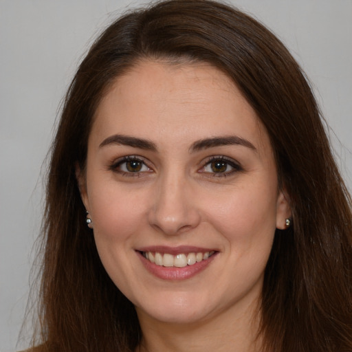 Joyful white young-adult female with long  brown hair and brown eyes