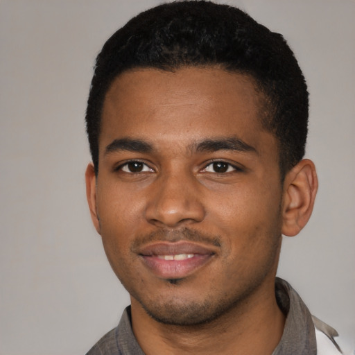 Joyful black young-adult male with short  brown hair and brown eyes