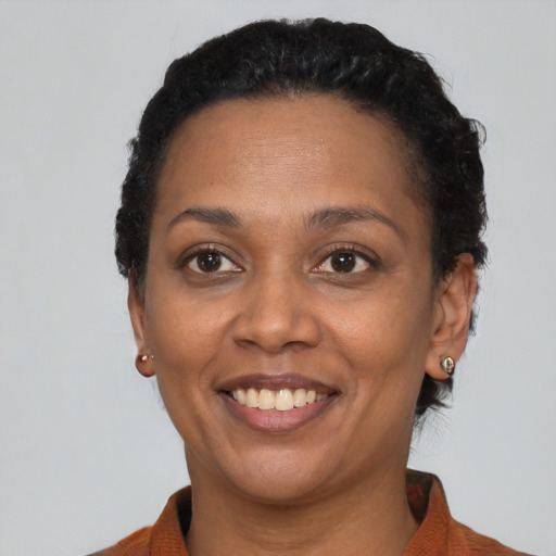 Joyful black adult female with short  black hair and brown eyes