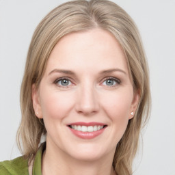 Joyful white young-adult female with medium  brown hair and green eyes