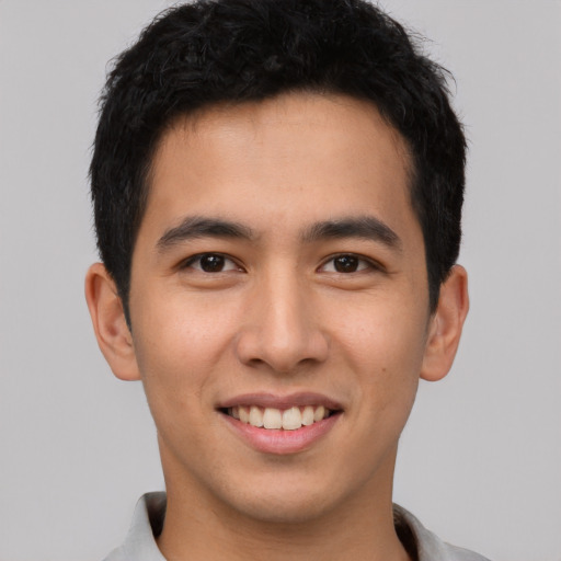 Joyful asian young-adult male with short  black hair and brown eyes