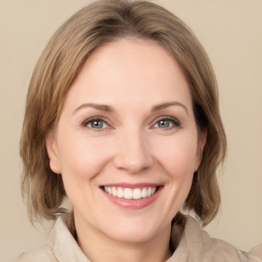 Joyful white young-adult female with medium  brown hair and green eyes