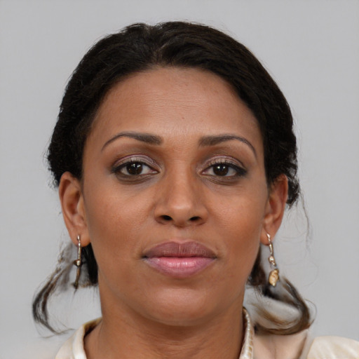 Joyful black adult female with medium  brown hair and brown eyes