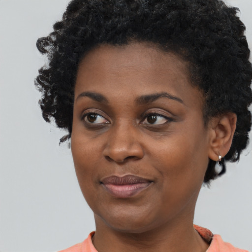 Joyful black young-adult female with short  black hair and brown eyes