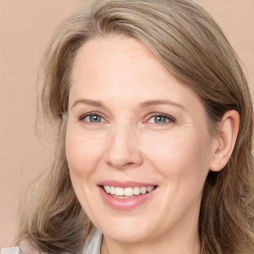 Joyful white adult female with long  brown hair and grey eyes