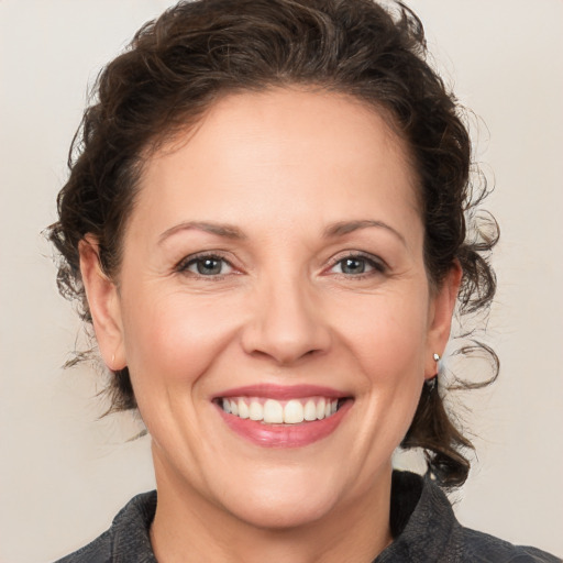 Joyful white adult female with medium  brown hair and brown eyes