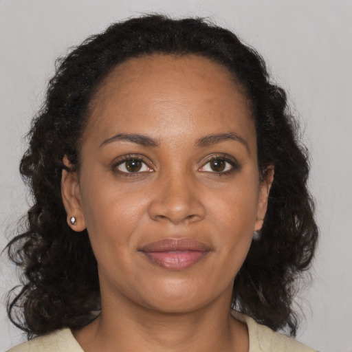 Joyful black young-adult female with medium  brown hair and brown eyes
