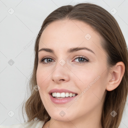 Joyful white young-adult female with long  brown hair and blue eyes