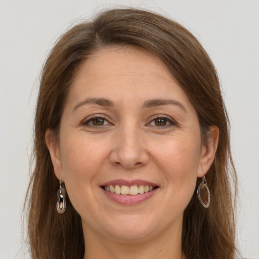 Joyful white adult female with long  brown hair and grey eyes