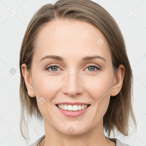 Joyful white young-adult female with medium  brown hair and grey eyes