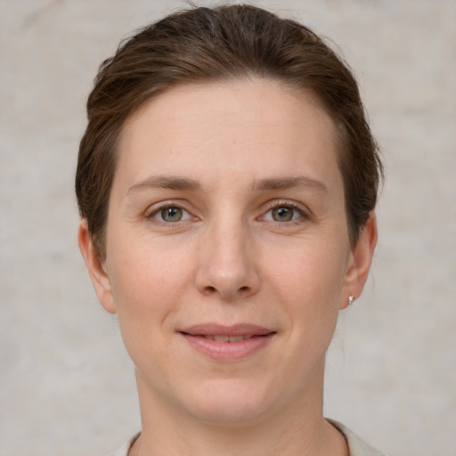 Joyful white young-adult female with short  brown hair and grey eyes