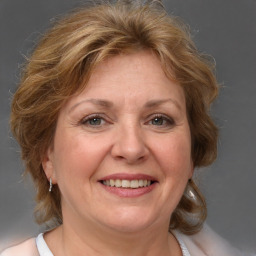 Joyful white adult female with medium  brown hair and blue eyes