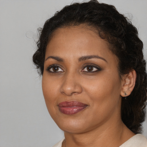 Joyful black young-adult female with medium  brown hair and brown eyes