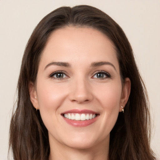 Joyful white young-adult female with long  brown hair and brown eyes