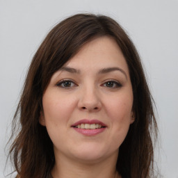 Joyful white young-adult female with long  brown hair and brown eyes