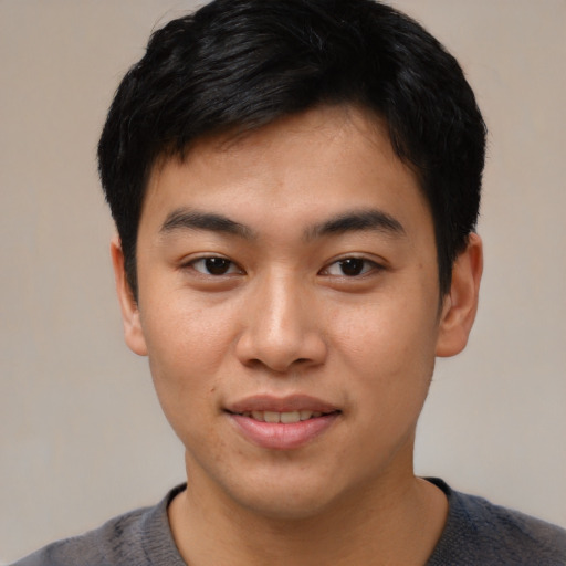 Joyful asian young-adult male with short  black hair and brown eyes