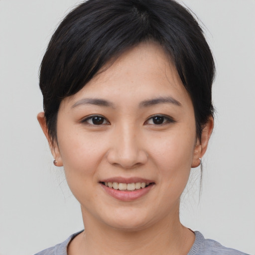 Joyful asian young-adult female with medium  brown hair and brown eyes