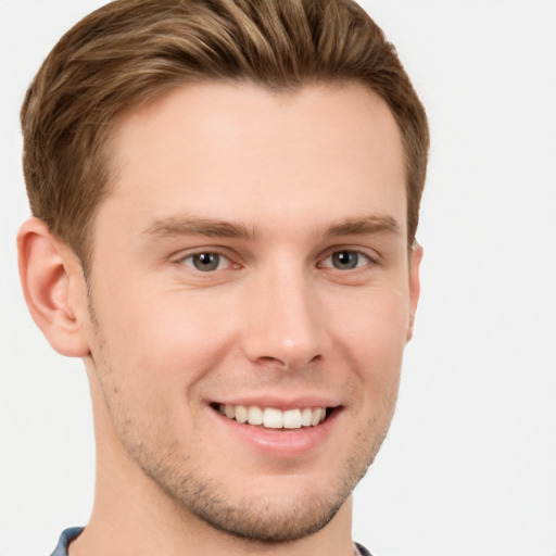 Joyful white young-adult male with short  brown hair and grey eyes