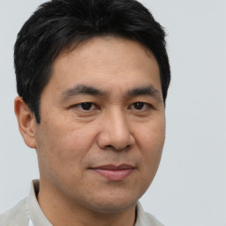 Joyful asian adult male with short  brown hair and brown eyes