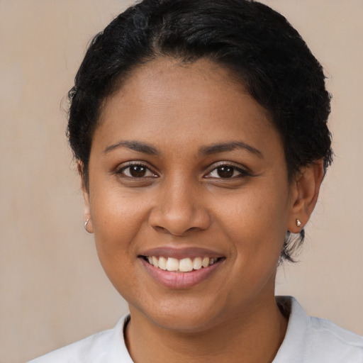 Joyful black young-adult female with short  brown hair and brown eyes