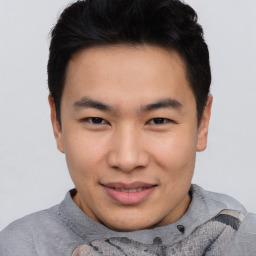 Joyful asian young-adult male with short  brown hair and brown eyes