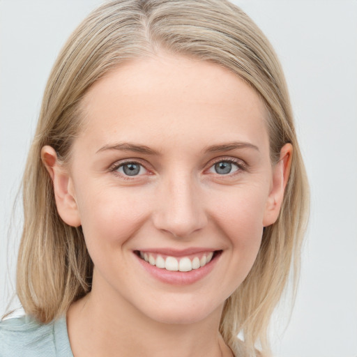 Joyful white young-adult female with medium  brown hair and blue eyes