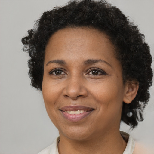 Joyful black adult female with short  brown hair and brown eyes