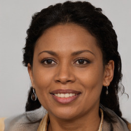 Joyful black adult female with long  brown hair and brown eyes