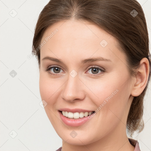 Joyful white young-adult female with medium  brown hair and grey eyes