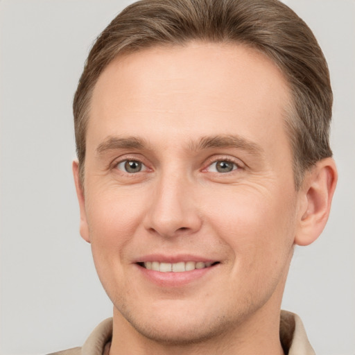 Joyful white young-adult male with short  brown hair and brown eyes