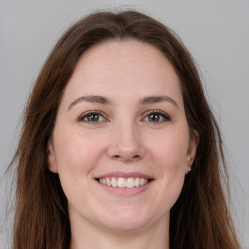 Joyful white young-adult female with long  brown hair and grey eyes