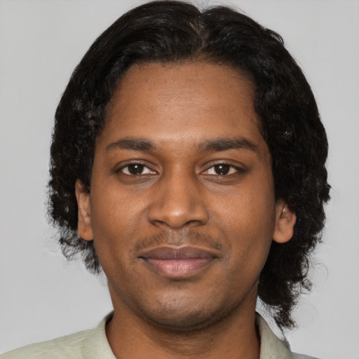 Joyful black young-adult male with short  black hair and brown eyes
