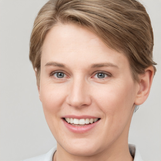 Joyful white young-adult female with short  brown hair and grey eyes