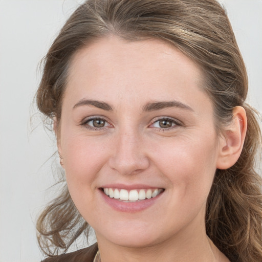 Joyful white young-adult female with medium  brown hair and grey eyes