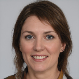 Joyful white young-adult female with medium  brown hair and blue eyes