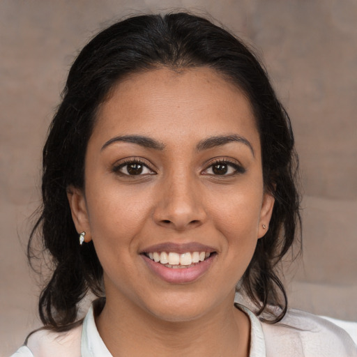 Joyful latino young-adult female with medium  brown hair and brown eyes