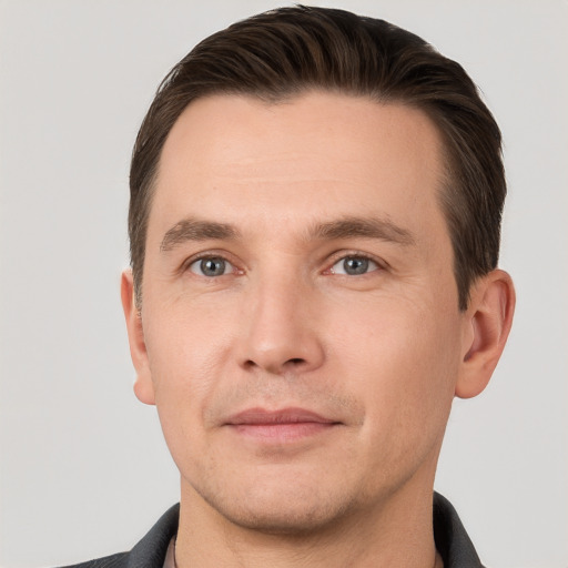 Joyful white young-adult male with short  brown hair and grey eyes