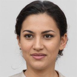 Joyful latino young-adult female with medium  brown hair and brown eyes