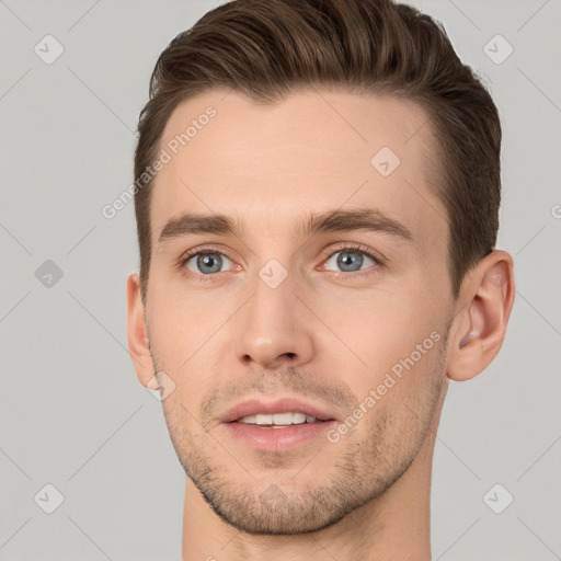 Joyful white young-adult male with short  brown hair and grey eyes