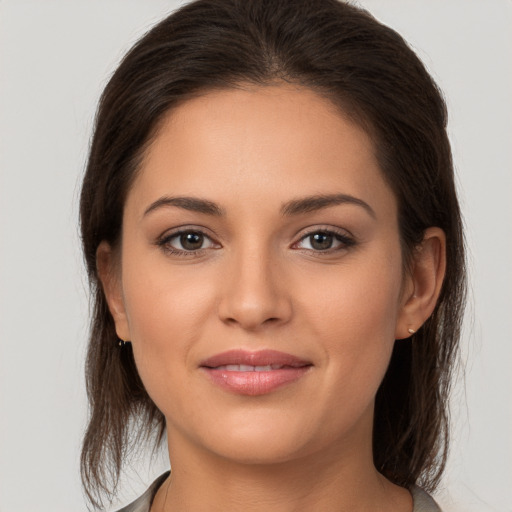 Joyful white young-adult female with long  brown hair and brown eyes