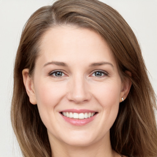 Joyful white young-adult female with long  brown hair and grey eyes