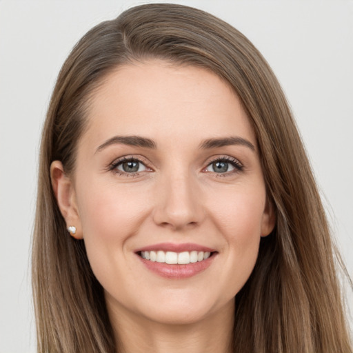 Joyful white young-adult female with long  brown hair and brown eyes