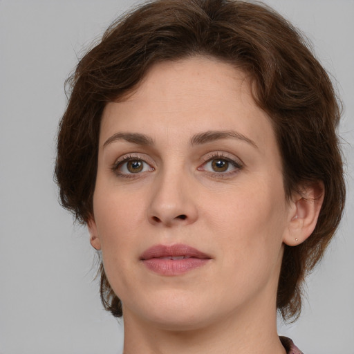 Joyful white young-adult female with medium  brown hair and green eyes