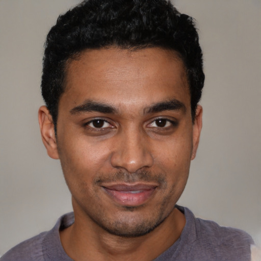 Joyful black young-adult male with short  black hair and brown eyes
